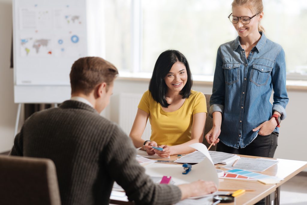 Positive cheerful designers working in team